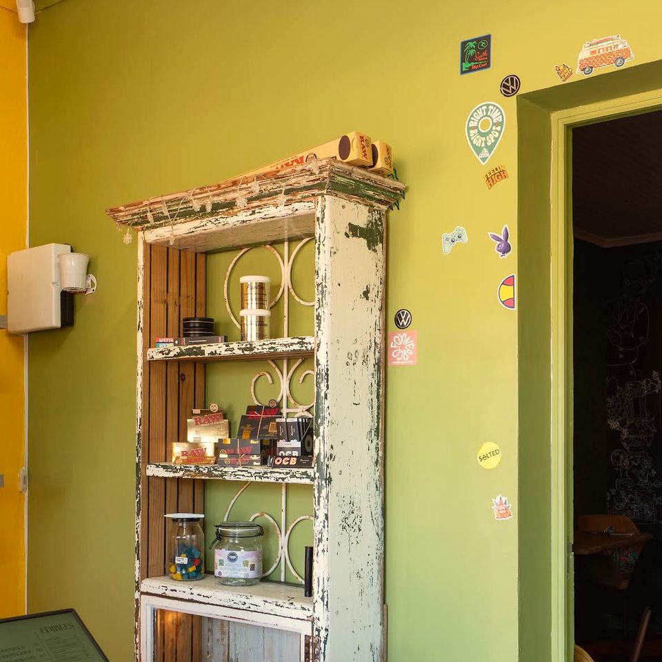 A weathered green apothecary cabinet with glass jars