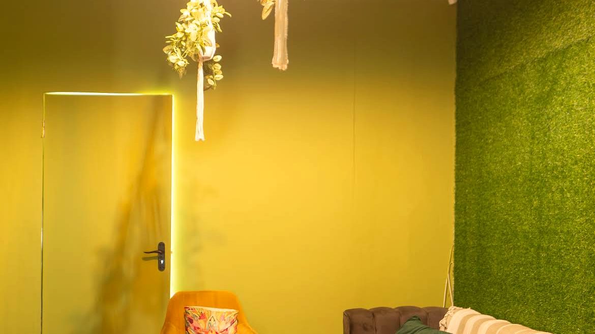The lounge: grass wall, striped couch, soft light